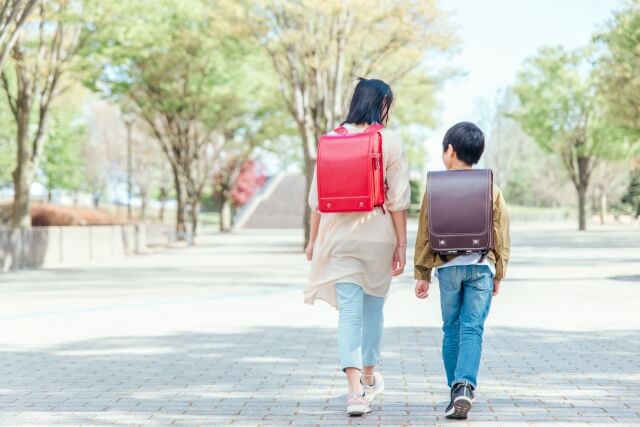 小学生の男女がランドセルを背負って一緒に歩いている写真