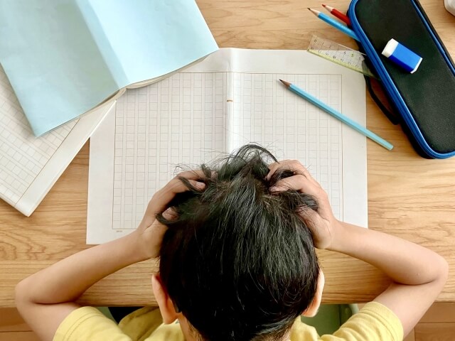 夏休みの宿題が終わらずに焦っている小学生の写真