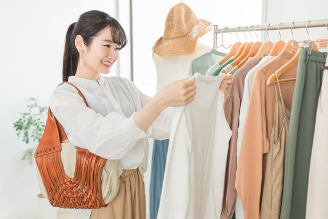 お店で洋服を選んでいる笑顔の女性の写真